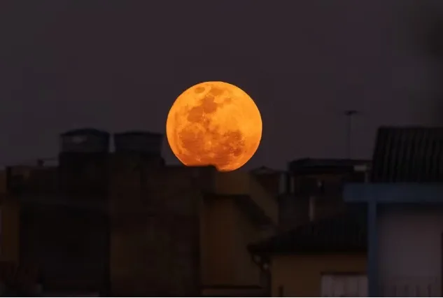 Lua aparece avermelhada no início da noite e chama atenção de moradores