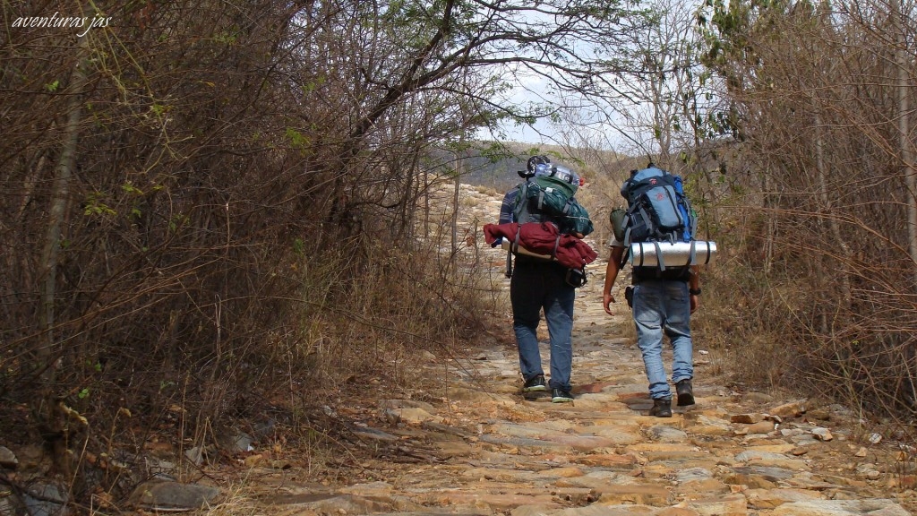 Trecho histórico da Estrada Real na Bahia, caminho de pedras cercado por natureza, usado para transporte de ouro no período colonial.