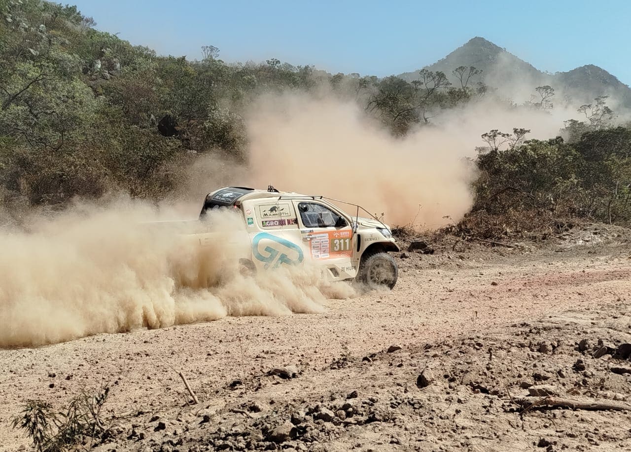 Carro do Rally dos Sertões levanta poeira ao atravessar trilha seca na região serrana de Macaúbas, Bahia.