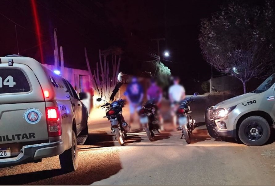 Policiais militares ao lado de três motocicletas apreendidas por direção perigosa em operação no Povoado da Barrinha, Livramento de Nossa Senhora.